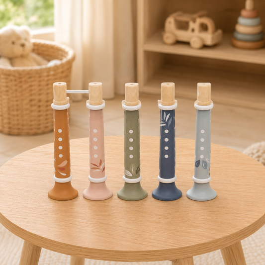 Trompettes enfant en bois Speedy Monkey posées sur une table en bois clair dans une chambre d’enfant douce et lumineuse.